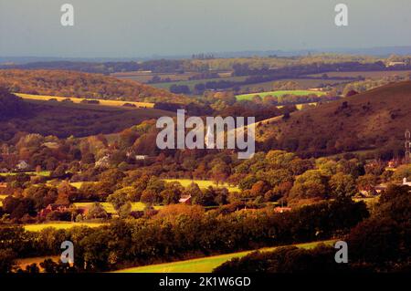 Die Farben des Herbstes umhüllen das Dorf East Meon in der Nähe von Petersfield, Hampshire, in der Morgensonne. Die Allerheiligen-Kirche aus dem 12.. Jahrhundert ist von Bäumen aller Schattierungen umgeben, bevor sie im Herbst ihre Blätter verlieren. Pic Mike Walker, Mike Walker Pictures Stockfoto