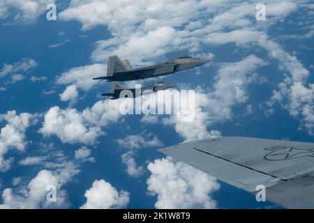 Die ein- und ausgehenden Kommandeure des 154.-Flügels fliegen F-22 Raptors in Formation mit einem KC-135 Stratotanker am 7. September 2022 in der Nähe von Oahu, Hawaii. Der Routine-Trainingsflug diente als Befehlswechsel während des Fluges als Brig. General dann S. Carlson gab das Kommando über den größten Flügel der Air National Guard an Oberst Phillip L. Mallory ab. (USA Foto der Air National Guard von Tech. Sgt. Nicholk Brown) Stockfoto