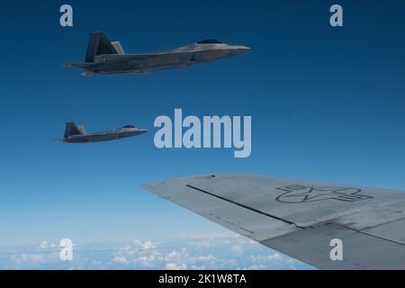 Die ein- und ausgehenden Kommandeure des 154.-Flügels fliegen F-22 Raptors in Formation mit einem KC-135 Stratotanker am 7. September 2022 in der Nähe von Oahu, Hawaii. Der Routine-Trainingsflug diente als Befehlswechsel während des Fluges als Brig. General dann S. Carlson gab das Kommando über den größten Flügel der Air National Guard an Oberst Phillip L. Mallory ab. (USA Foto der Air National Guard von Tech. Sgt. Nicholk Brown) Stockfoto