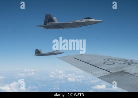 Die ein- und ausgehenden Kommandeure des 154.-Flügels fliegen F-22 Raptors in Formation mit einem KC-135 Stratotanker am 7. September 2022 in der Nähe von Oahu, Hawaii. Der Routine-Trainingsflug diente als Befehlswechsel während des Fluges als Brig. General dann S. Carlson gab das Kommando über den größten Flügel der Air National Guard an Oberst Phillip L. Mallory ab. (USA Foto der Air National Guard von Tech. Sgt. Nicholk Brown) Stockfoto