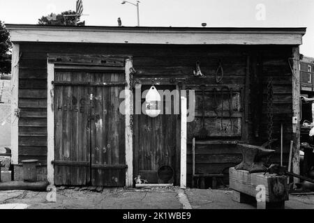 The Dog House - ein verwitterter Holzschuppen an den Docks in Gloucester Harbour, Massachusetts. Das Bild wurde auf analogem Schwarzweiß-Film aufgenommen. Stockfoto