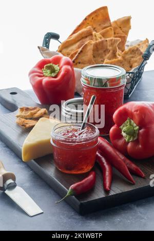 Eine Anordnung von Paprikagelee mit Crackerbrot und Käse. Stockfoto