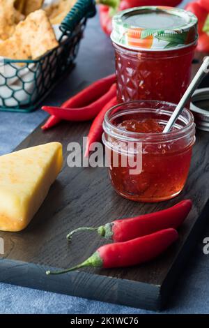 Gläser mit köstlichem hausgemachtem Peperoni-Gelee mit Käse und Crackern. Stockfoto