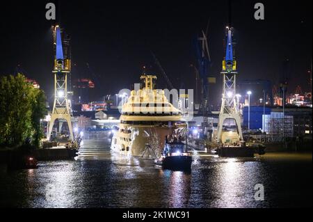 Hamburg, Deutschland. 21. September 2022. Die Luxusyacht 'Dilbar' wird von Schleppern vom überfluteten Trockendock der Werft Blohm Voss auf die Elbe vor den Landebrücken geschleppt. Um das Trockendock 'Elbe 17' in Hamburg für die Reparatur anderer Schiffe freizumachen, wird die Yacht ohne eigene Motorleistung per Schlepper zu einem anderen Liegeplatz in Bremen geschleppt. Die Luxusyacht „Dilbar“ wurde im April 2022 aufgrund von EU-Sanktionen aufgrund der Invasion russischer Truppen in der Ukraine festgenommen. Quelle: Jonas Walzberg/dpa/Alamy Live News Stockfoto