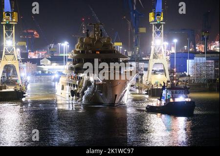 Hamburg, Deutschland. 21. September 2022. Die Luxusyacht 'Dilbar' wird von Schleppern vom überfluteten Trockendock der Werft Blohm Voss auf die Elbe vor den Landebrücken geschleppt. Um das Trockendock 'Elbe 17' in Hamburg für die Reparatur anderer Schiffe freizumachen, wird die Yacht ohne eigene Motorleistung per Schlepper zu einem anderen Liegeplatz in Bremen geschleppt. Die Luxusyacht „Dilbar“ wurde im April 2022 aufgrund von EU-Sanktionen aufgrund der Invasion russischer Truppen in der Ukraine festgenommen. Quelle: Jonas Walzberg/dpa/Alamy Live News Stockfoto