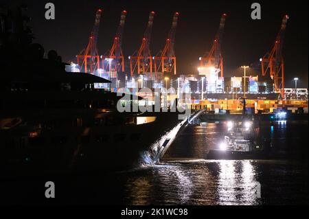 Hamburg, Deutschland. 21. September 2022. Die Luxusyacht 'Dilbar' wird von Schleppern vom überfluteten Trockendock der Werft Blohm Voss auf die Elbe vor den Anlegestegen am Containerterminal Burchardkai vorbei geschleppt. Um das Trockendock 'Elbe 17' in Hamburg für die Reparatur anderer Schiffe freizumachen, wird die Yacht ohne eigene Motorleistung per Schlepper zu einem anderen Liegeplatz in Bremen geschleppt. Die Luxusyacht „Dilbar“ wurde im April 2022 aufgrund von EU-Sanktionen aufgrund der Invasion russischer Truppen in der Ukraine festgenommen. Quelle: Jonas Walzberg/dpa/Alamy Live News Stockfoto