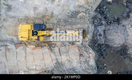 Yellow Raupe Bulldozer führt Erdarbeiten - Luftaufnahme. Yellow Raupe Traktor reckt den Boden, um eine asphaltierte Straße zu bauen. Erdthen Bulldozer arbeitet während des Baus der Route Straße. Hochwertige Fotos Stockfoto