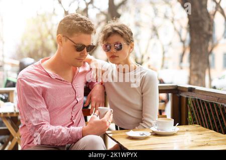 Flirten in einem Café. Schönes liebevolles Paar, das in einem Café sitzt, Kaffee trinkt und im Gespräch genießt. Liebe, Romantik, Dating. Mann und Frau sitzen vor der Cafeteria und genießen Kaffee Stockfoto