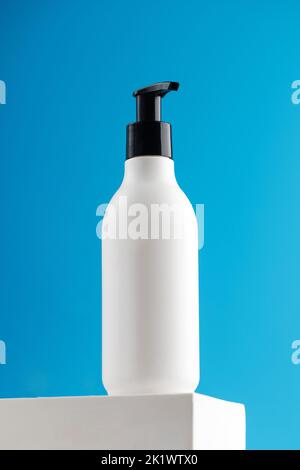 Modell eines weißen Dispensers mit einem kosmetischen Produkt mit einem Platz für Ihr Logo auf einem Podium. Stockfoto