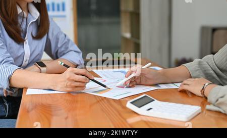 Zwei professionelle asiatische Finanzberaterinnen diskutieren und arbeiten zusammen an einem Geschäftsfinanzbericht Stockfoto