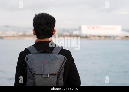 Glücklicher Mann in Mantel und Kamera, asiatische Reisende genießen und Sightseeing-Blick im Schiff Stockfoto