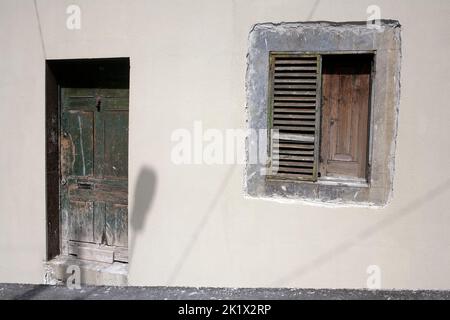 Graue Wand mit abblätternder grün gestrichenen Tür und Fensterläden im Norden von Funchal Madeira Stockfoto