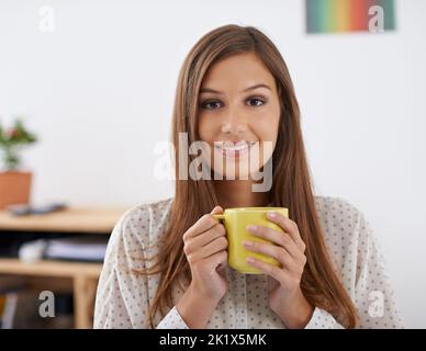 Ich liebe den Geruch der Möglichkeit am Morgen. Porträt einer schönen jungen Frau, die eine Tasse Kaffee in der Hand hält. Stockfoto