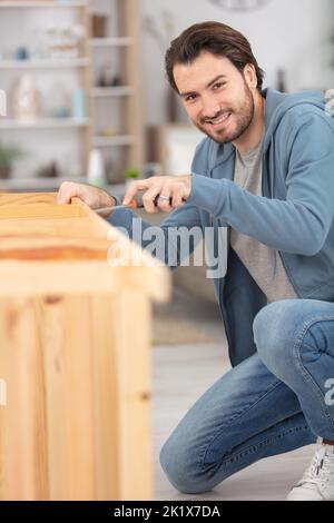 frustriert Mann Zusammenstellung Selbstmontage Möbel Stockfoto