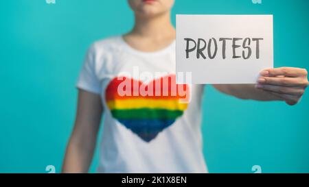 Frauenrechtsprotest. Soziale Demonstration. Gleichstellung der Geschlechter. Weibliche Empowerment. Entkoketes Mädchen mit Zeichen gegen Diskriminierung im T-Shirt mit Regenbauch Stockfoto