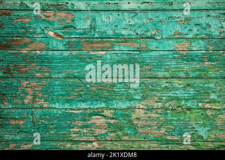 Altes Holzbrett mit abblätternder Farbe. Textur Hintergrund der grünen schuppigen Farbe auf gerissenen Planke aus Holz Stockfoto