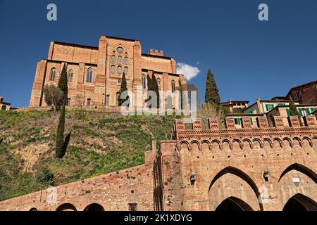 Siena, Toskana, Italien: Blick auf die mittelalterliche Kirche Basilika San Domenico auf dem Hügel über der antiken Quelle Fontebranda in der Altstadt der Ci Stockfoto