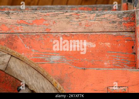 Eine lackierte Oberfläche eines Holzwagens mit Seitenwänden und Rand eines Wagenrades. Geeignet als Hintergrund oder als Element. Stockfoto