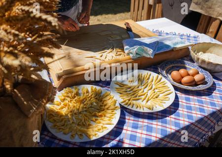 Alte Dame, die frische Pasta von Hand zubereitet Stockfoto