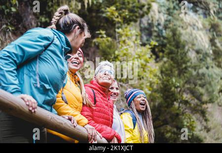 Multirassische Frauen, die Spaß haben, die Natur an einem Trekking-Tag im Bergwald zu erkunden - konzentrieren Sie sich auf das Gesicht der mittleren älteren Frau Stockfoto