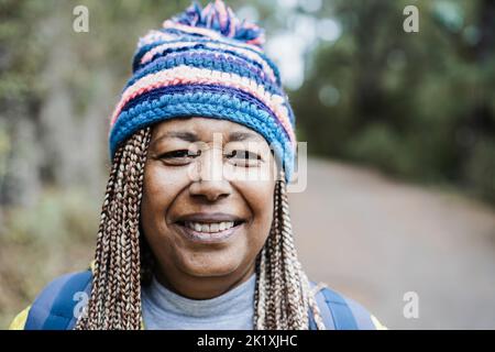 Porträt einer älteren afrikanischen Frau, die während des Trekkingtages im Bergwald Spaß hat - Fokus auf Gesicht Stockfoto