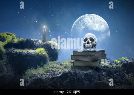 Stapel des Buches mit einem menschlichen Schädel und Kerzenlicht mit dem Hintergrund der Nachtszene Stockfoto