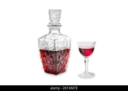 Likör aus roter Kirsche in Glasflasche, verziert mit Vintage-Glas mit dekorativen Gravuren, isoliert auf weißem, schneidendem Pfad Stockfoto