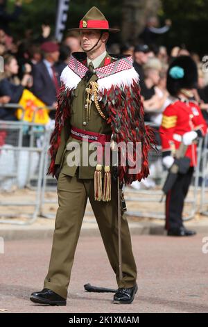 Ein Mitglied der Royal New Zealand Army trägt einen traditionellen zeremoniellen Mantel (Korowai) bei der Beerdigung von Königin Elizabeth, der zweiten, während sie auf einem Geschützwagen von Westminster Abbey die Mall hinunter getragen wird, bedeckt von der Royal Standard Flagge und der Imperial State Crown, Orb und Zeptre. Stockfoto