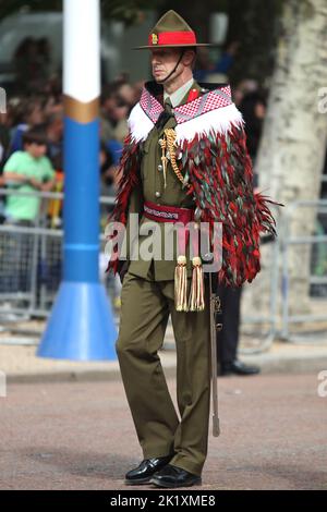 Ein Mitglied der Royal New Zealand Army trägt einen traditionellen zeremoniellen Mantel (Korowai) bei der Beerdigung von Königin Elizabeth, der zweiten, während sie auf einem Geschützwagen von Westminster Abbey die Mall hinunter getragen wird, bedeckt von der Royal Standard Flagge und der Imperial State Crown, Orb und Zeptre. Stockfoto