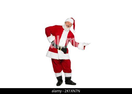 Porträt eines älteren Mannes im Bild des Weihnachtsmanns, der mit positivem Ausdruck auf weißem Hintergrund isoliert posiert. Vorschlag Stockfoto