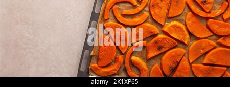 Banner von gehackten gebackenen süßen Butternut-Kürbis auf einem Backblech, Draufsicht Stockfoto