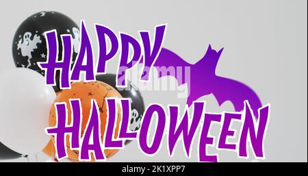 Bild von halloween Text über Luftballons und Fledermaus auf grauem Hintergrund Stockfoto