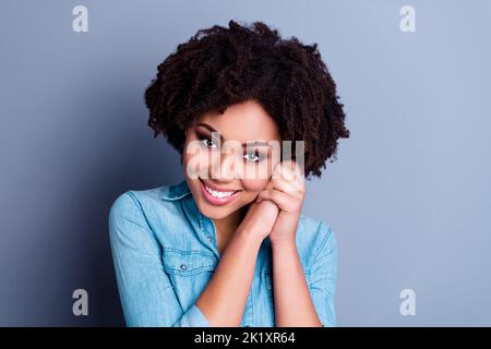 Portrait von wunderschönen fröhlich Dame gefaltet Arme Handflächen unter Wange strahlend Lächeln isoliert auf grauem Hintergrund Stockfoto