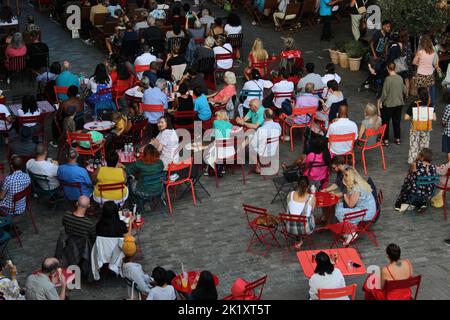 Die Menschen versammeln sich im Coal Drops Yard zum Kings Cross Summer Sounds Festival im Sommer 2022. Konzept für Leute, die gesellig sind, auswärts essen, Sonntagsbrunch Stockfoto