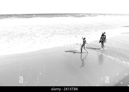 Arenales del Sol, Alicante, Spanien - 18. September 2022: Mutter und Tochter sonnen sich und spazieren an einem sonnigen Sommertag am Strand entlang Stockfoto