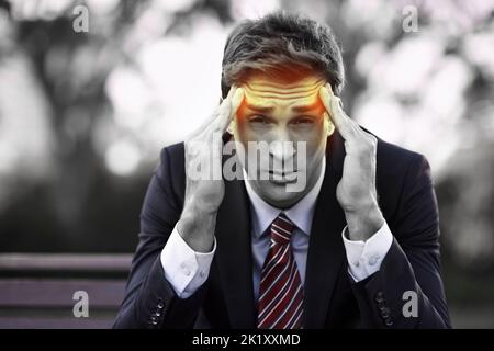 Ich brauche wirklich eine Pause...Porträt eines gestressten jungen Geschäftsmannes, der auf einer Parkbank sitzt. Stockfoto
