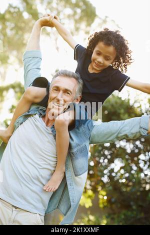 Hes eine solche Freude für mich. Ein Großvater spielt mit seinem Enkel im Park. Stockfoto