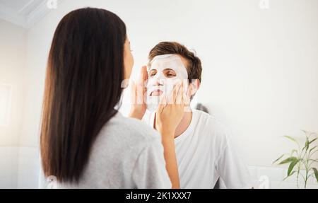 Paar Gesichtsbehandlung im Badezimmer, Schönheitsmaske Reiniger auf Mann Gesicht und Hautpflege Wellness-Produkt. Kosmetische Reinigung, junge Ehe zusammen und schön Stockfoto