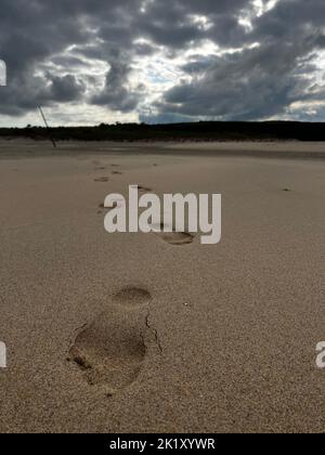 Fußspuren im Sand am Strand Stockfoto