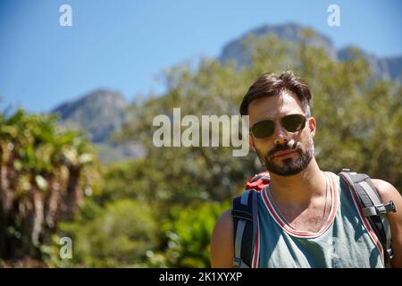Bereit, diesen Gipfel zu erreichen. Ein Wanderer mit einem Rucksack auf dem Rücken. Stockfoto