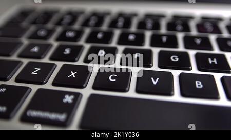 Nahaufnahme der Makropanoramabasierung der Tastatur auf dem Laptop-Computer. Langsamer Makro-Softfokus-Dolly-Shot. 4K Aufnahmen einer modernen Laptop-Tastatur Stockfoto