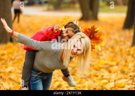 Mutter und Tochter im Stadtpark im Herbst Spaß haben. Stockfoto