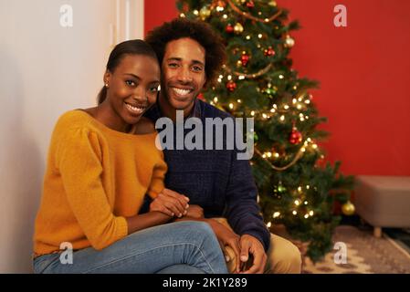 Es ist eine Zeit, sich zu freuen. Porträt eines liebevollen jungen Paares zu Weihnachten. Stockfoto