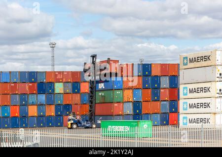 In Stapeln gestapelte Container, die von oben angeordneten Maschinen am Kai, Hafen von Felixstowe, Suffolk, England, Großbritannien, gehoben wurden Stockfoto