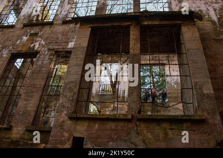 Ein Blick durch die Ruinen einer alten Mühle, Fenster zur Natur und zu Touristen; durch das schauende Glas. Stockfoto