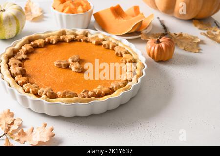 Thanksgiving Day American Pumpkin Pie dekoriert Herbstblätter auf weißem Hintergrund. Nahaufnahme. Speicherplatz kopieren. Stockfoto