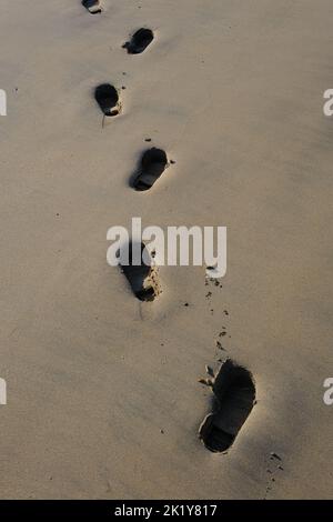 Fußspuren im Sand am Strand Stockfoto