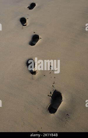 Fußspuren im Sand am Strand Stockfoto