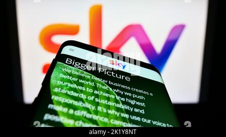 Mobiltelefon mit Webseite des britischen Medienunternehmens Sky Group Limited auf dem Bildschirm vor dem Unternehmenslogo. Konzentrieren Sie sich auf die obere linke Seite des Telefondisplays. Stockfoto