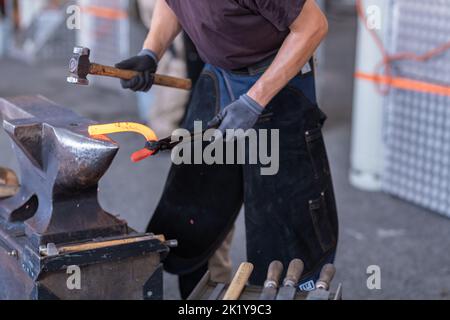 Ein Schmied, der in der Schmiede Hufeisen macht Stockfoto